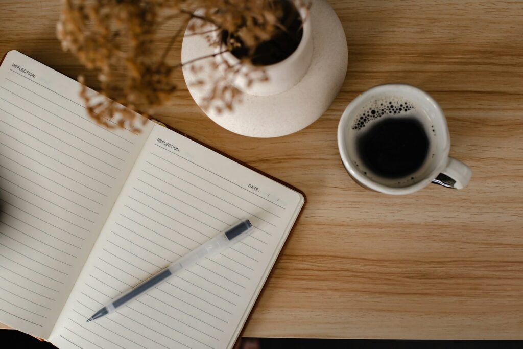 a cup of coffee and a notebook on a table for the Diary of Jesus post