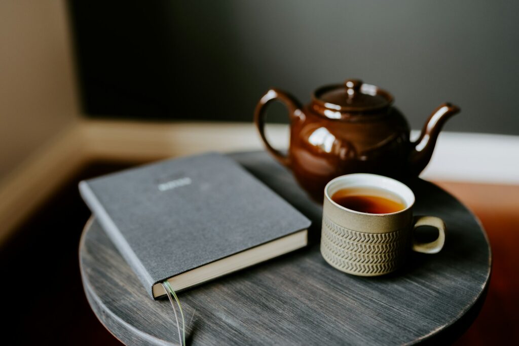 A cup of tea and a book on a table for Finding Grace post