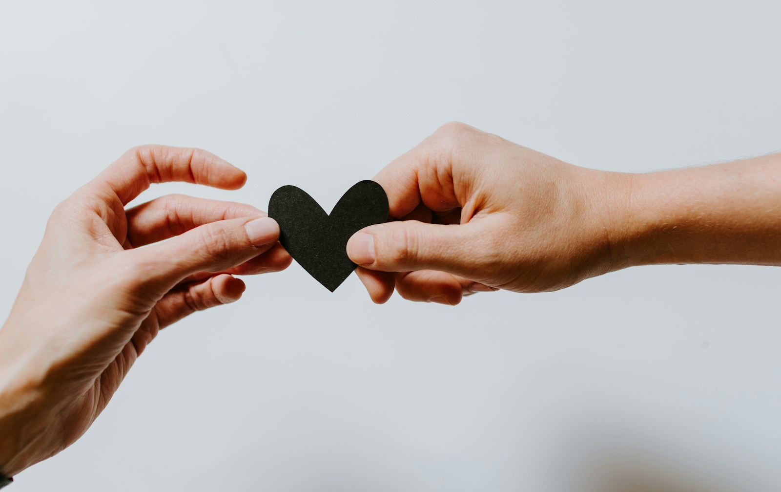two person holding papercut heart for devotional Finding Hope Amidst Loss