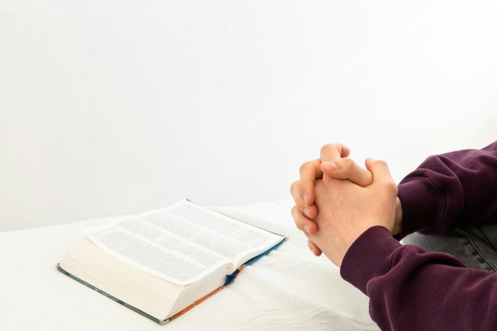 a person sitting at a table with an open book for devotional in my brokenness