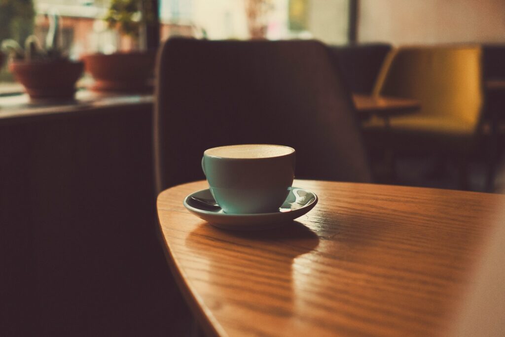 shallow focus photography of teacup with saucer on top of wooden table for devotional A Seat Before My Enemies
