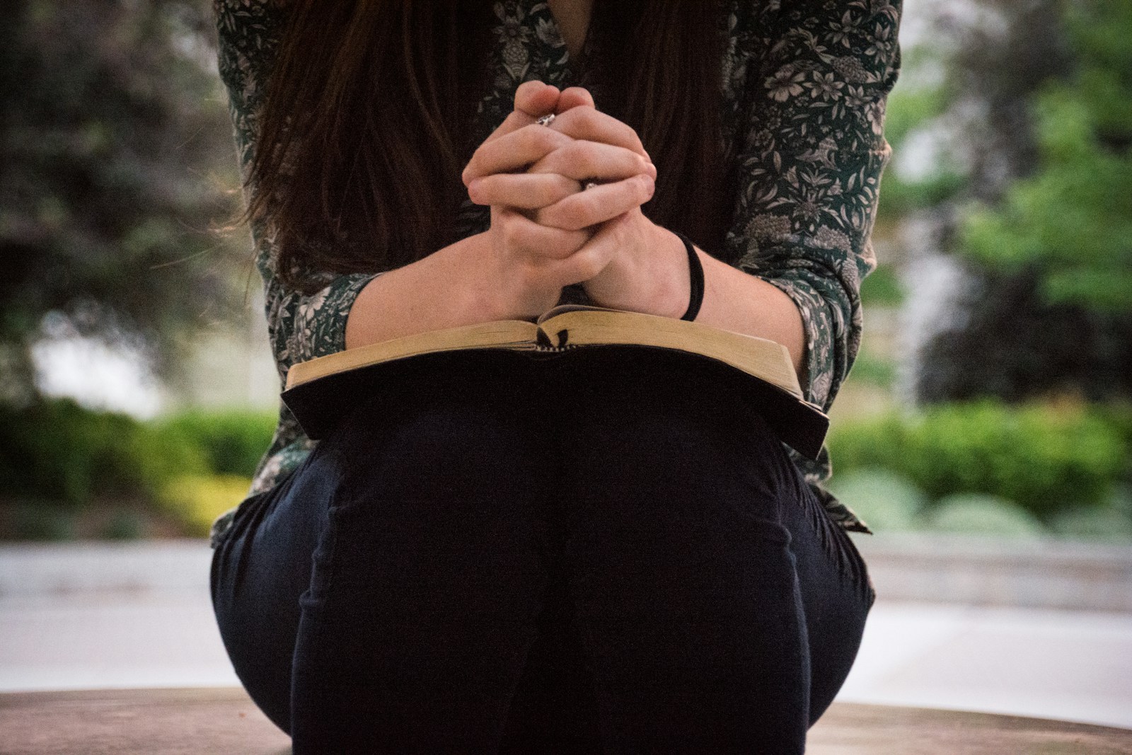 person sitting while reading book for devotional Trusting in God’s Plan